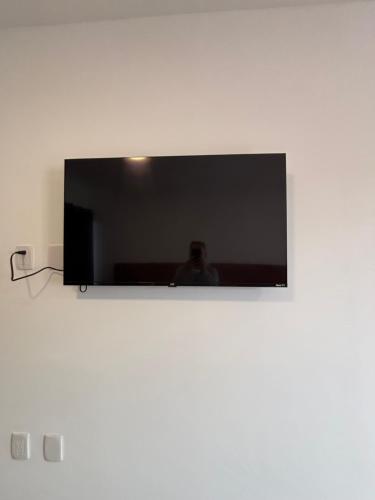 a flat screen tv hanging on a white wall at KC Suites in Comitán