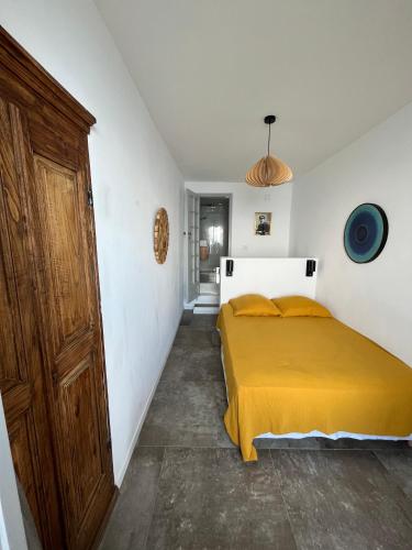 a bedroom with a bed with a yellow blanket at Large period house with panoramic view in Canari