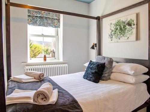 a bedroom with a bed with pillows and a window at 2 Bed in Bakewell oc-90406 in Bakewell