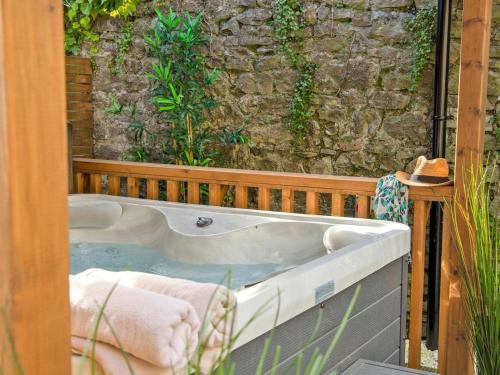 a bath tub sitting in front of a stone wall at 2 Bed in Bakewell oc-90406 in Bakewell