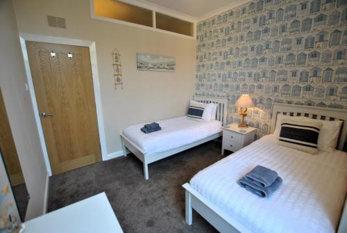 a bedroom with two beds and a door in it at Kirkmay House Apartment in Crail