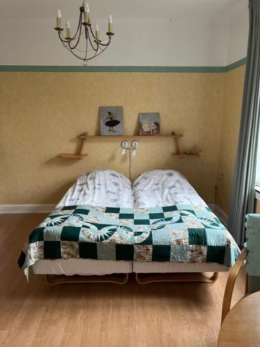 a bedroom with a bed with a quilt on it at Nygammelsø Bed & Breakfast in Stege