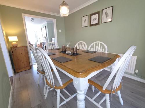 a dining room table with white chairs around it at Alverstoke Manor - family home with pool table in Alverstoke