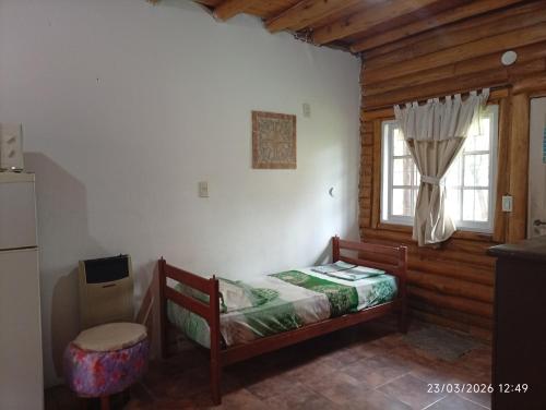 a small bedroom with a bed and a window at Cabañas la calma in Concordia