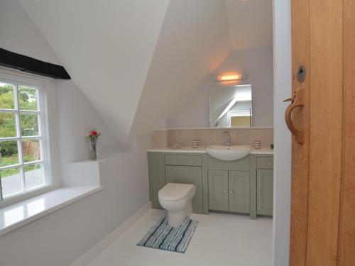 a bathroom with a toilet and a sink and a window at 1 Bed in Sherborne oc-51018 in Bradford Abbas