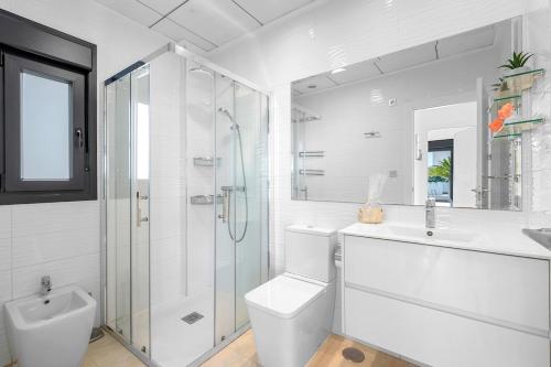 a white bathroom with a shower and a toilet and a sink at Villa Sol in Orihuela Costa
