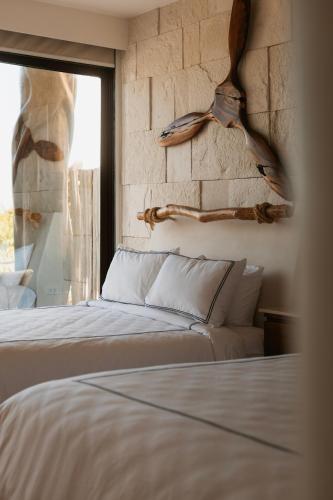 a bedroom with a white bed and a window at Beach House Costa Yucatan by Trobbu Collection in Xtampú