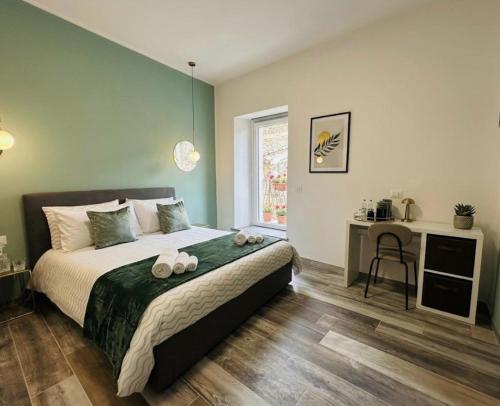 a bedroom with a bed with a desk and a window at WelcHome Vitorchiano Guest House in Vitorchiano