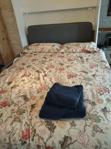 a bed with a blue hat sitting on it at Stay in Annascaul Village at Aido's in Anascaul