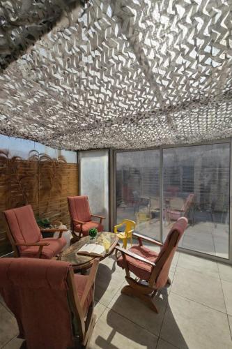 a living room with chairs and a table and a ceiling at Maison classée 3étoiles proche plage in Mauguio