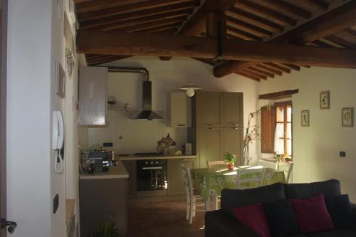 a kitchen and a living room with a table and chairs at Alla Porta di Sopra in Castiglione dʼOrcia