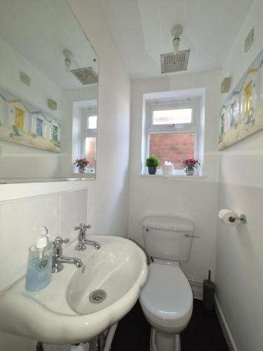 a white bathroom with a toilet and a sink at Alverstoke Manor - family home with pool table in Alverstoke