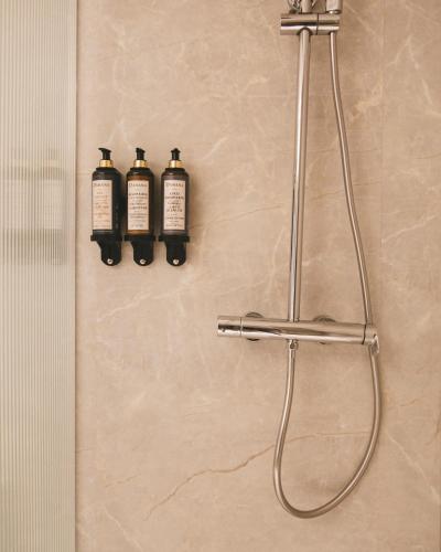 three bottles of shampoo are hanging on a bathroom wall at Honest Granada Apartments in Granada