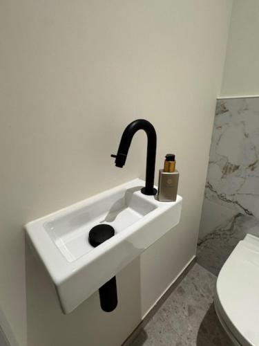 a sink with a faucet in a bathroom at The Corner-MARGO in Beernem