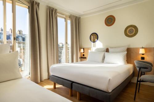 una camera d'albergo con due letti e una finestra di Korner République a Parigi