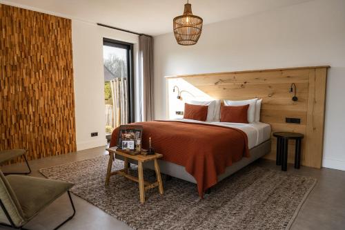 a bedroom with a large bed and a table at Hoeve BuytenHout in Delft