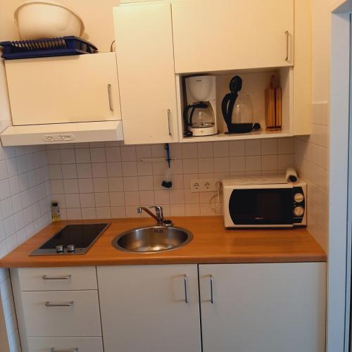 a small kitchen with a sink and a microwave at FW Knütel Nr 59 in Burgtiefe auf Fehmarn 