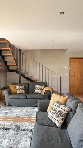 a living room with a couch and a staircase at Casa das Castanhas - Cinfães, Viseu in Cinfães