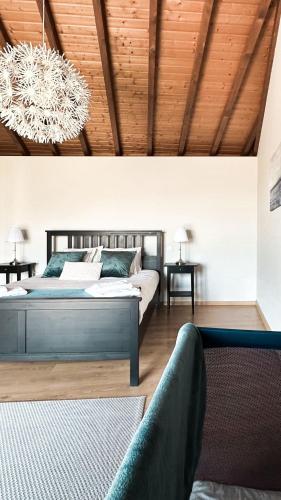a bedroom with a bed and a chandelier at Casa das Castanhas - Cinfães, Viseu in Cinfães