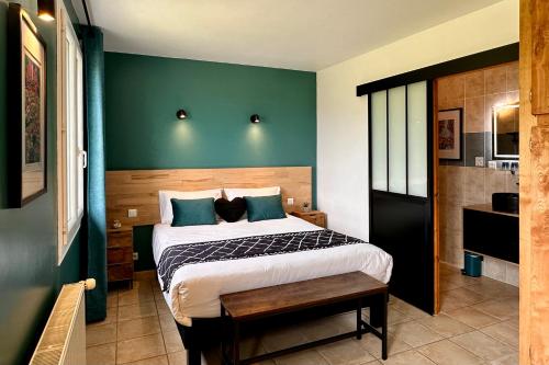 a bedroom with a bed and a green wall at L'Ostal de Soubrey in Salettes