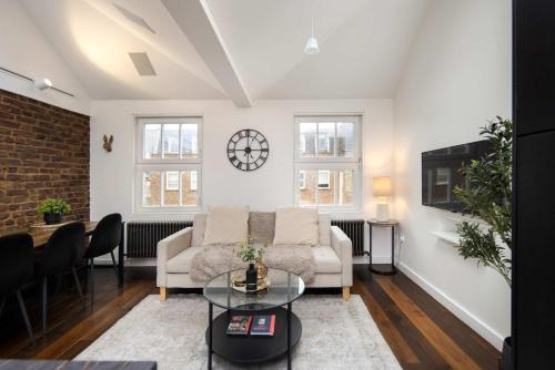 a living room with a couch and a table at 1 Min Walk to Euston Station, Modern Townhouse in London