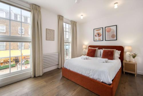 a bedroom with a large bed and a large window at 1 Min Walk to Euston Station, Modern Townhouse in London
