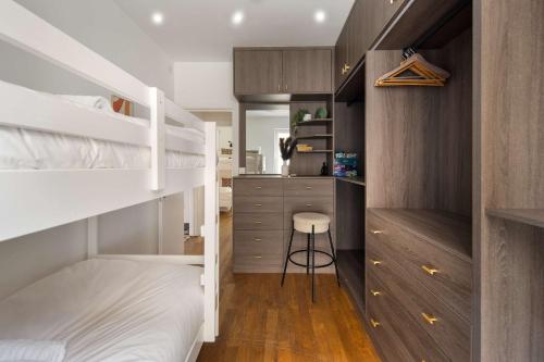 a small bedroom with bunk beds and a stool at 1 Min Walk to Euston Station, Modern Townhouse in London