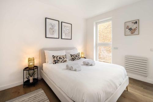 a bedroom with a white bed with two towels on it at 1 Min Walk to Euston Station, Modern Townhouse in London