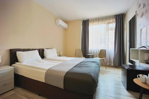 a hotel room with a large bed and a television at Hotel Leda in Sofia