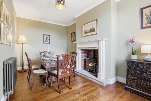 a dining room with a table and a fireplace at Lantern House - North East Escapes in Belford
