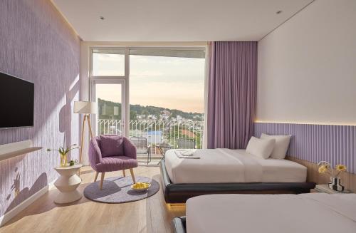 a hotel room with a bed and a balcony at Adela Hotel Dalat in Da Lat