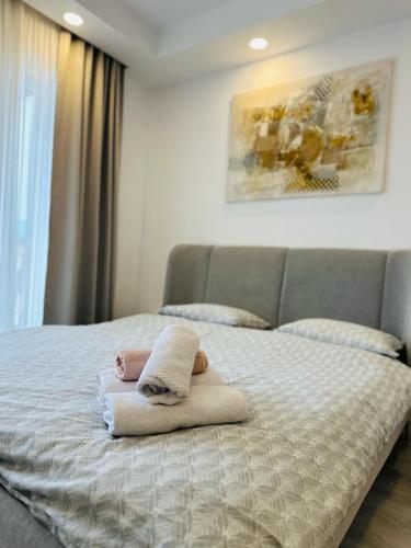 a bedroom with a bed with towels on it at Anturium Studio #Otopeni #freePool in Tunari