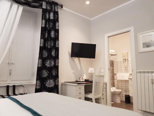 a bedroom with a bed and a desk and a television at Residenza Vatican Suite in Rome