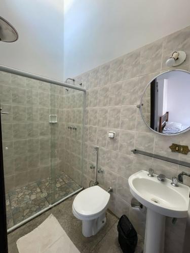 a bathroom with a shower and a toilet and a sink at Pousada Lourenço in Nazaré Paulista