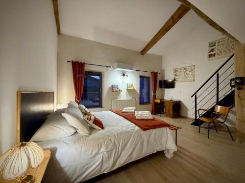 a bedroom with a large white bed in a room at A l'ombre des vignes, chambres d'hôtes 3 épis avec piscine in Poncin