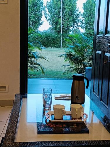 a table with a coffee pot and two cups on it at Chandras palace hotel kothar in Kothār