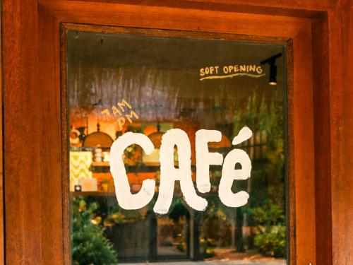 a sign in a window that reads cafe at Copacabana Siargao Boutique Hotel & Artcafé in General Luna