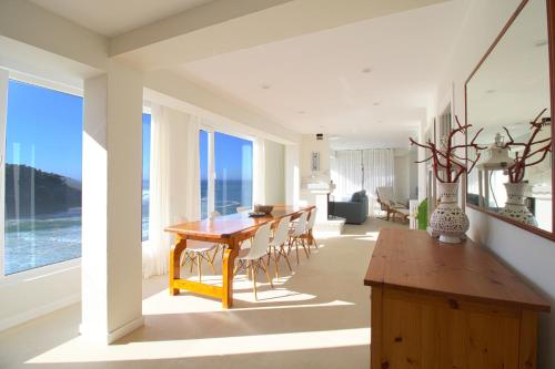 a dining room and living room with a table and chairs at Luaña Beach House in Cóbreces
