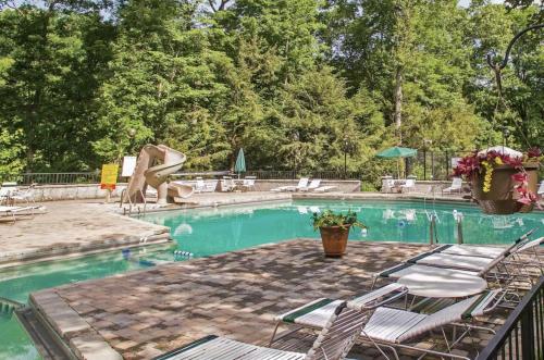 a swimming pool with chairs and a slide at Falling Brook – Cozy Creekside Cabin with Hot Tub, Game Loft & Dog-Friendly Comfort in Gatlinburg