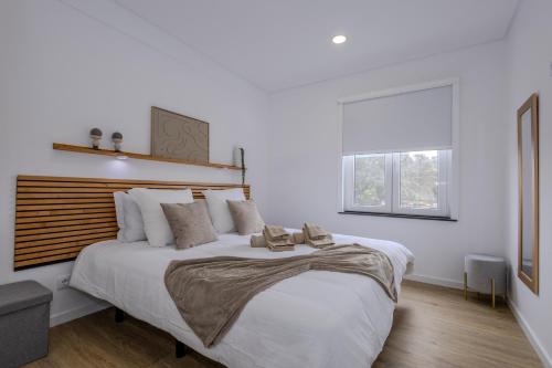 a large white bedroom with a large bed with pillows at Nono Guest House in Ribeira Grande