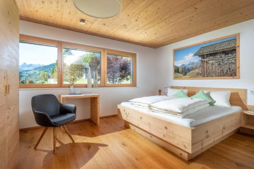 a bedroom with a bed and a desk and a chair at Appartements Veronika in Silbertal