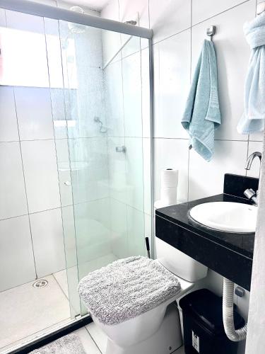 a bathroom with a shower and a toilet and a sink at Edifício AES Brasil in Cairu