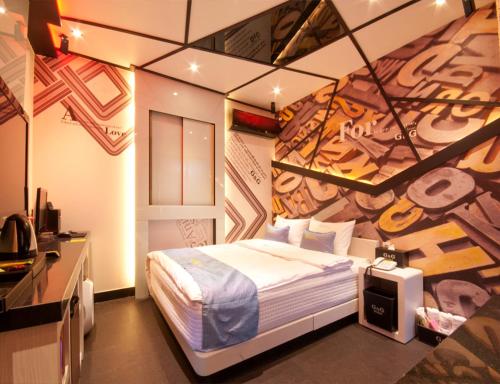 チンジュにあるJinju GnG Motelの壁に絵が飾られたベッドのある寝室