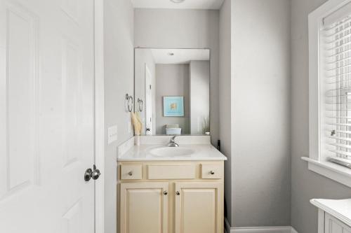 a bathroom with a sink and a mirror at Just Peachy VillageOBX in Kill Devil Hills