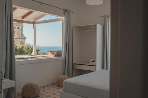 a bedroom with a bed and a view of a tower at Casacasa Praiano in Praiano