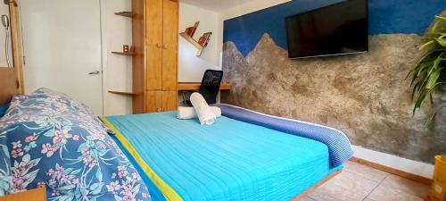 a bedroom with a bed and a flat screen tv at Punto DF - Airport in Mexico City