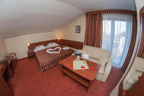 a hotel room with a bed and a table at Hotel Rypsówka in Nowy Sącz