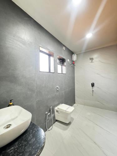 a bathroom with a sink and a toilet in it at SeaYou Stay in Daman