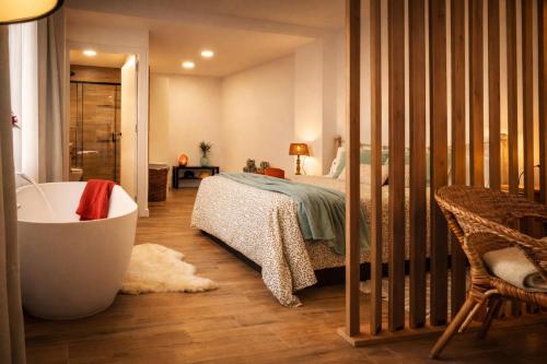a bedroom with a bed and a tub in a room at Private Loft Sant Celoni, Montseny, Barcelona in Sant Celoni