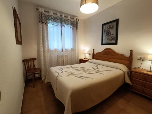 a bedroom with a large bed and a window at Apartamento Maladeta in Torla-Ordesa